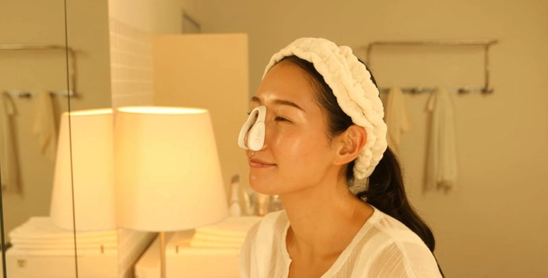 Woman applying skincare in warm evening light after sculpting